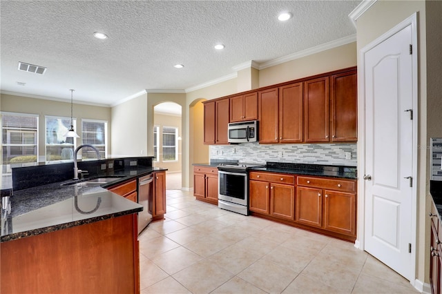 4484 Gray Hawk St, Orange Park, FL 32065 - kitchen with visible vents, appliances with stainless steel finishes, arched walkways, a sink, and backsplash