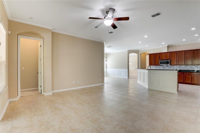 4484 Gray Hawk St, Orange Park, FL 32065 - kitchen featuring crown molding, stainless steel microwave, arched walkways, ceiling fan, and visible vents