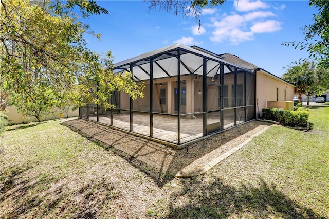 4484 Gray Hawk St, Orange Park, FL 32065 - rear view of property with glass enclosure, ceiling fan, stucco siding, a lawn, and a patio area