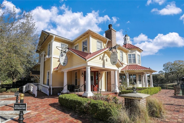 4484 Gray Hawk St, Orange Park, FL 32065 - view of front of home featuring metal roof, a chimney, brick siding, a standing seam roof, and a porch