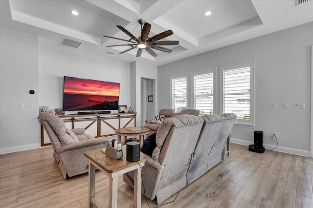 living area with baseboards, coffered ceiling, visible vents, ceiling fan, and light wood finished floors
