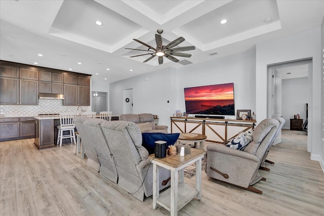 living room with coffered ceiling, light wood-style floors, ceiling fan, and beamed ceiling