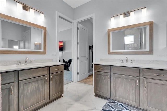 bathroom featuring two vanities, marble finish floor, and a sink