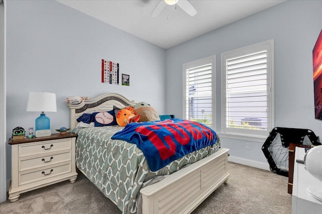 carpeted bedroom featuring baseboards and a ceiling fan