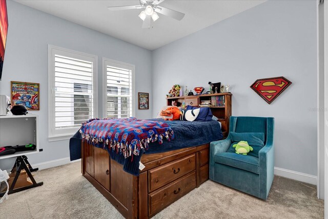 bedroom with baseboards, multiple windows, ceiling fan, and light carpet