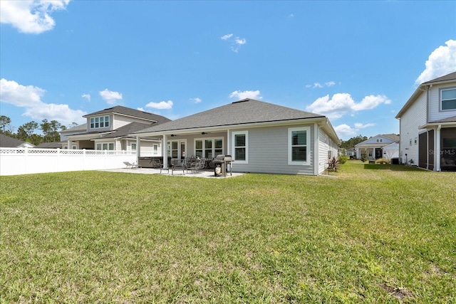 rear view of property featuring a patio area, fence, a lawn, and ceiling fan