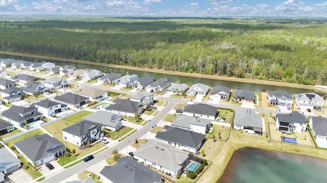 drone / aerial view with a view of trees, a residential view, and a water view