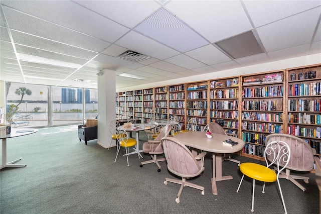 925 N Halifax Ave Unit 1105, Daytona Beach, FL 32118 - interior space with a drop ceiling, visible vents, bookshelves, a wall of windows, and carpet flooring