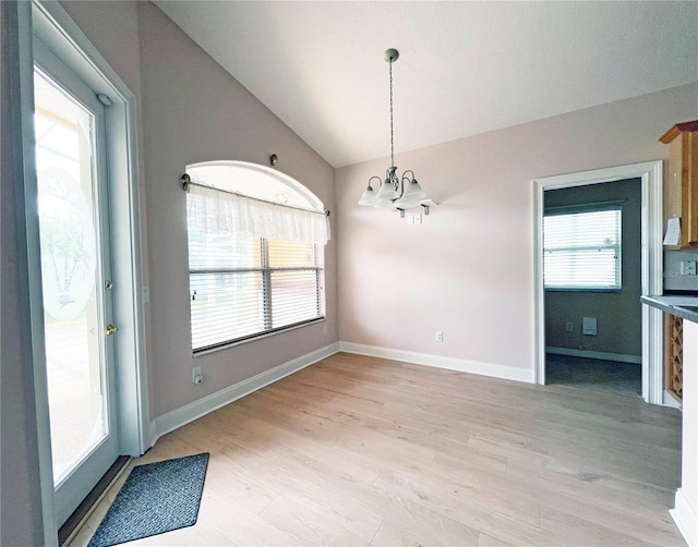 161 Frontier Dr, Palm Coast, FL 32137 - unfurnished dining area featuring a chandelier, light wood-style floors, vaulted ceiling, and baseboards
