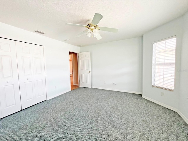 161 Frontier Dr, Palm Coast, FL 32137 - unfurnished bedroom with baseboards, carpet flooring, a closet, and a textured ceiling