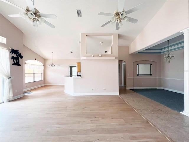 161 Frontier Dr, Palm Coast, FL 32137 - unfurnished living room featuring high vaulted ceiling, ceiling fan, a chandelier, arched walkways, and light wood-style floors