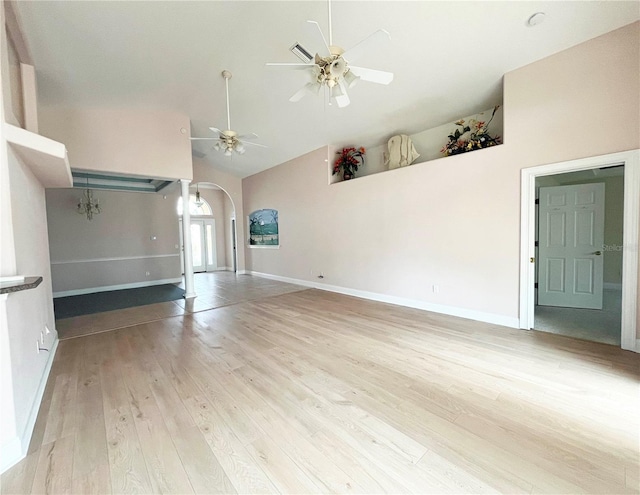 161 Frontier Dr, Palm Coast, FL 32137 - unfurnished living room with arched walkways, a ceiling fan, light wood-style flooring, high vaulted ceiling, and baseboards