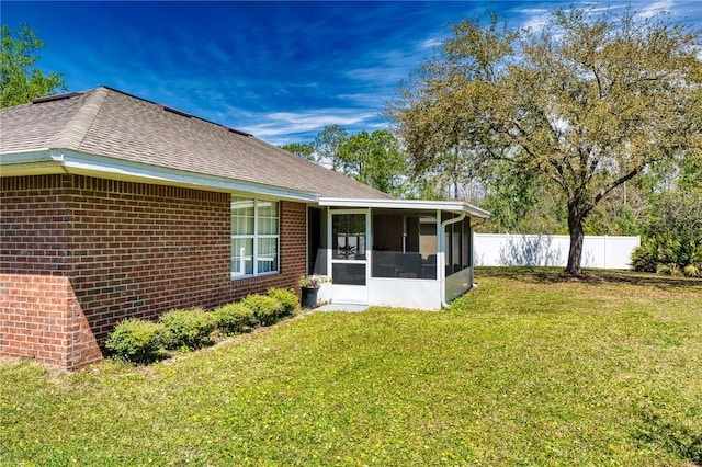 73 Royal Oak Dr, Palm Coast, FL 32164 - view of home's exterior featuring a lawn, a sunroom, fence, and brick siding