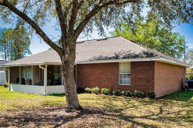 73 Royal Oak Dr, Palm Coast, FL 32164 - rear view of property with a shingled roof, a sunroom, brick siding, and a yard