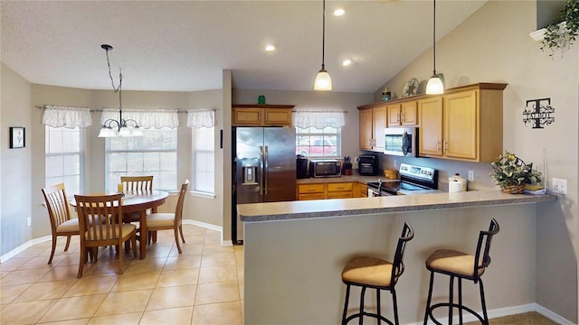 73 Royal Oak Dr, Palm Coast, FL 32164 - kitchen featuring light tile patterned flooring, a toaster, a peninsula, appliances with stainless steel finishes, and a kitchen breakfast bar