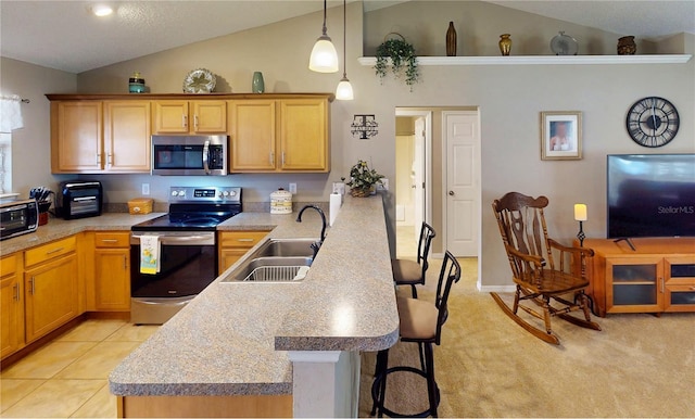 73 Royal Oak Dr, Palm Coast, FL 32164 - kitchen featuring a sink, a kitchen bar, appliances with stainless steel finishes, a peninsula, and light tile patterned floors