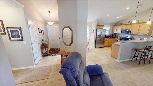 73 Royal Oak Dr, Palm Coast, FL 32164 - kitchen featuring a breakfast bar area, light brown cabinetry, a peninsula, light carpet, and appliances with stainless steel finishes