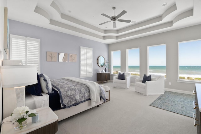 46 Ocean Ridge Blvd N, Palm Coast, FL 32137 - bedroom featuring carpet, a raised ceiling, view of water and beach, a ceiling fan, and baseboards