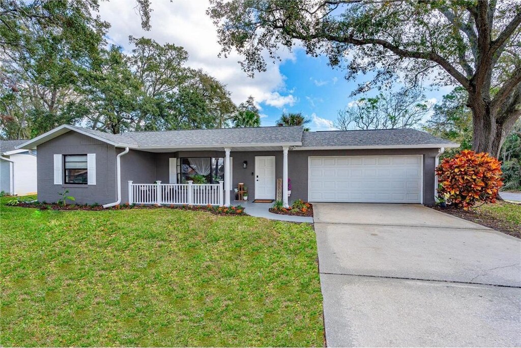 1433 Mollie Rd, Daytona Beach, FL 32114 - single story home with a porch, driveway, a front lawn, and a garage