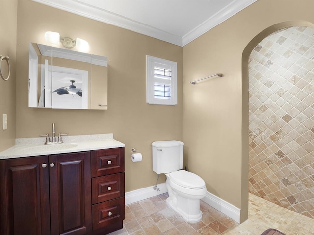 full bathroom featuring crown molding, baseboards, vanity, toilet, and tiled shower