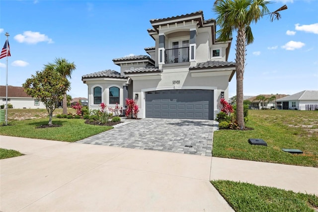 7 Menorca Way, Palm Coast, FL 32137 - mediterranean / spanish house featuring a front yard, decorative driveway, a balcony, an attached garage, and stucco siding