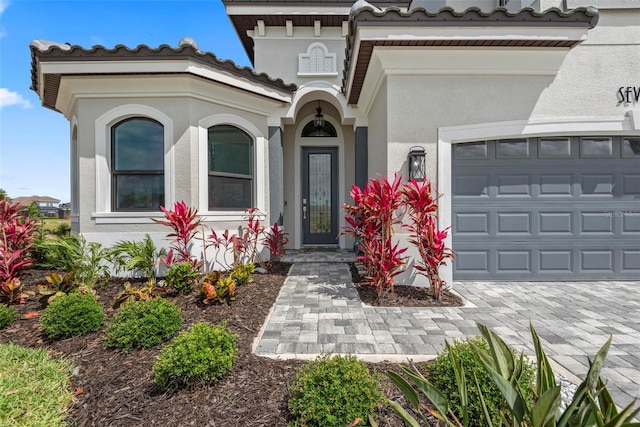 7 Menorca Way, Palm Coast, FL 32137 - property entrance with a garage, stucco siding, decorative driveway, and a tile roof