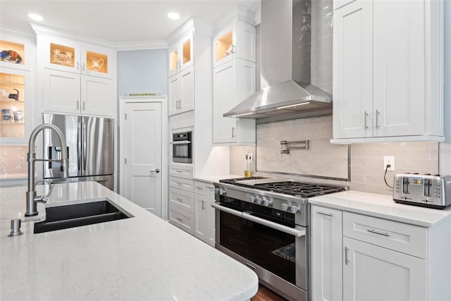 7 Menorca Way, Palm Coast, FL 32137 - kitchen with decorative backsplash, wall chimney range hood, white cabinets, a sink, and appliances with stainless steel finishes