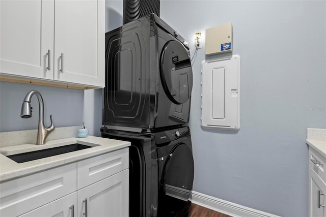 7 Menorca Way, Palm Coast, FL 32137 - clothes washing area featuring stacked washer and clothes dryer, baseboards, dark wood-style floors, a sink, and cabinet space
