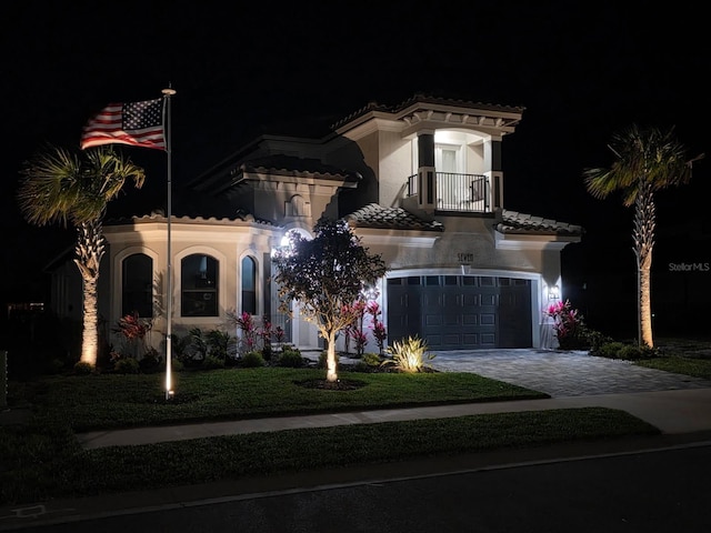 7 Menorca Way, Palm Coast, FL 32137 - mediterranean / spanish-style house featuring an attached garage, a tile roof, stucco siding, decorative driveway, and a balcony