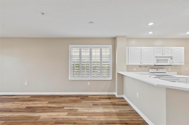 500 Canopy Walk Ln Unit 515, Palm Coast, FL 32137 - kitchen featuring white appliances, white cabinetry, light countertops, light wood-style floors, and recessed lighting