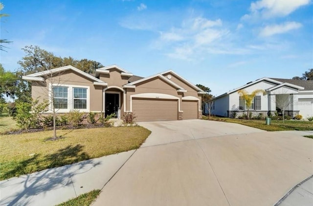 ranch-style house featuring driveway, stucco siding, a garage, and a front yard