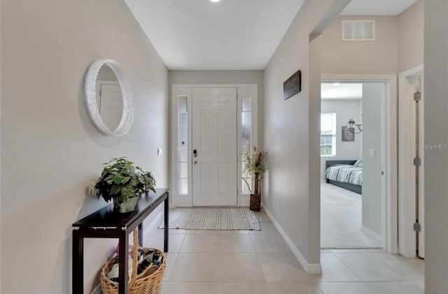 entryway with baseboards, visible vents, and light tile patterned floors