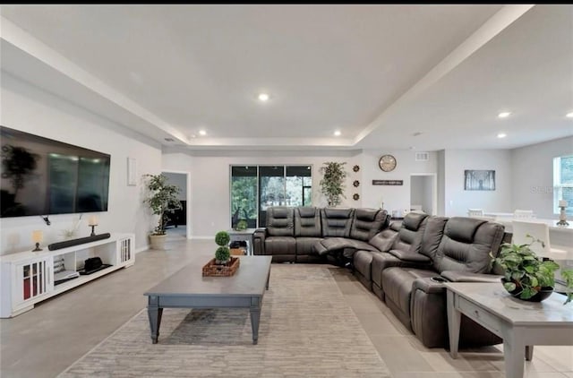 living area with a tray ceiling, baseboards, and recessed lighting