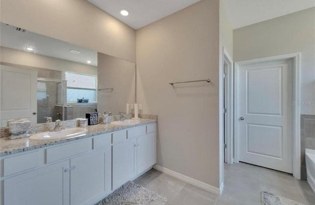 bathroom with a washtub, baseboards, double vanity, a sink, and a stall shower