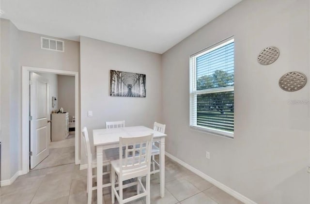 dining area featuring baseboards, visible vents, and light tile patterned floors