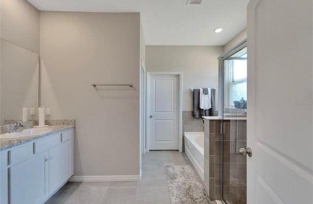 bathroom featuring tile patterned floors, vanity, a garden tub, baseboards, and visible vents