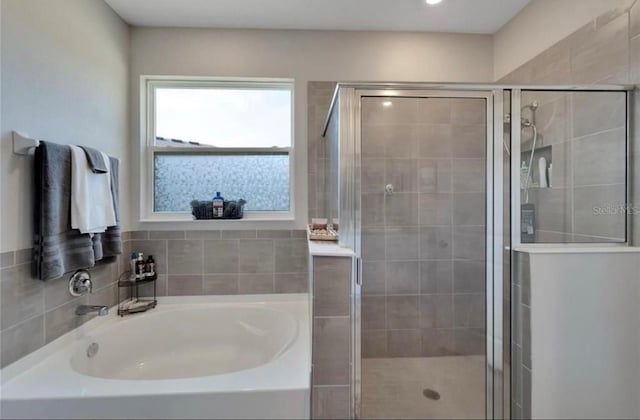 full bathroom with a garden tub and a shower stall