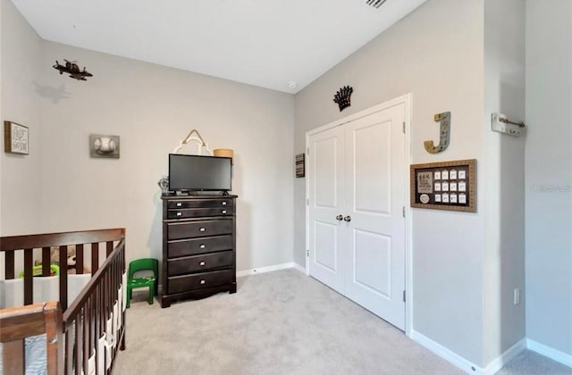 bedroom with a closet, baseboards, and light colored carpet