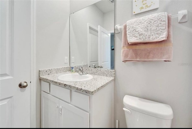half bathroom featuring toilet and vanity