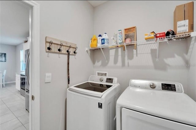 washroom featuring independent washer and dryer, laundry area, and light tile patterned floors