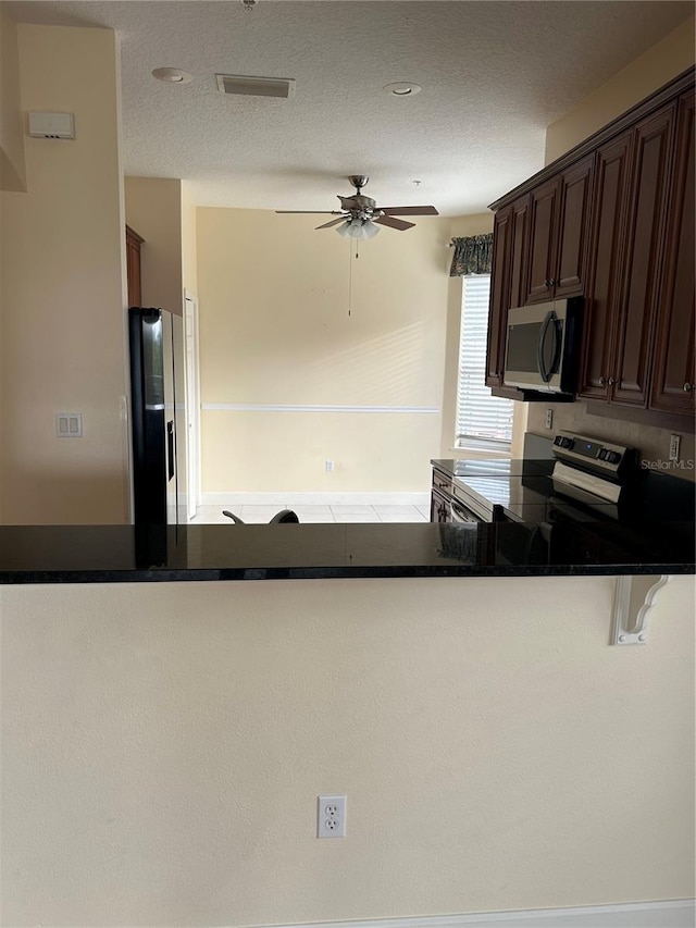 15 Ocean Crest Way Unit 1335, Palm Coast, FL 32137 - kitchen with a textured ceiling, stainless steel appliances, dark brown cabinets, and a ceiling fan