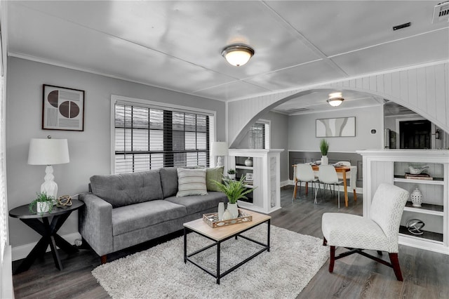 living area with arched walkways, baseboards, dark wood-style floors, and visible vents