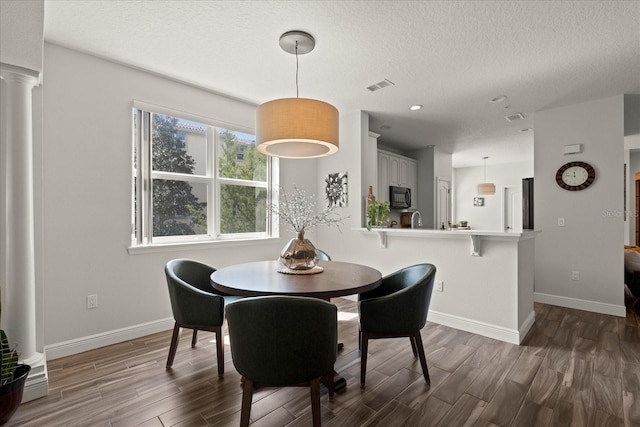 45 Riverview Bnd S Unit 1926, Palm Coast, FL 32137 - dining area featuring decorative columns, dark wood finished floors, a textured ceiling, baseboards, and recessed lighting