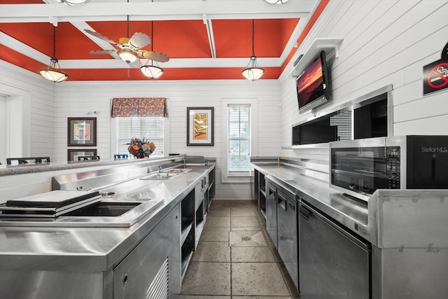 45 Riverview Bnd S Unit 1926, Palm Coast, FL 32137 - kitchen with stainless steel counters, stainless steel microwave, wood walls, hanging light fixtures, and dark cabinets