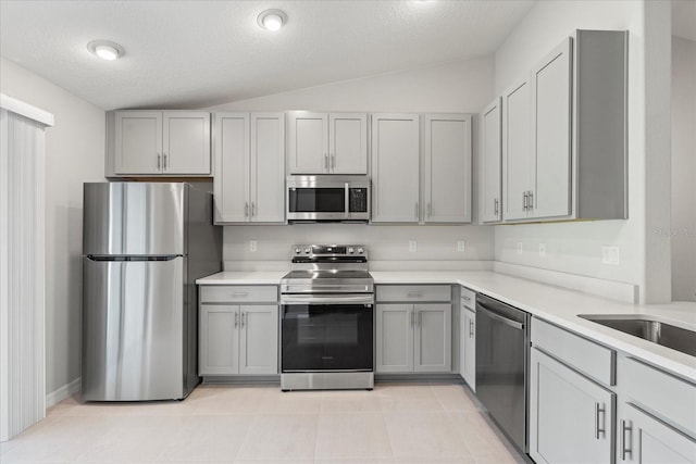 29 Secretary Trl, Palm Coast, FL 32164 - kitchen featuring light countertops, stainless steel appliances, gray cabinets, vaulted ceiling, and light tile patterned floors