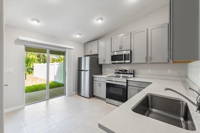 29 Secretary Trl, Palm Coast, FL 32164 - kitchen with a sink, stainless steel appliances, gray cabinetry, and vaulted ceiling