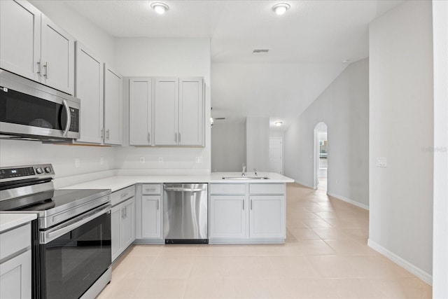 29 Secretary Trl, Palm Coast, FL 32164 - kitchen with light countertops, stainless steel appliances, a sink, arched walkways, and a peninsula