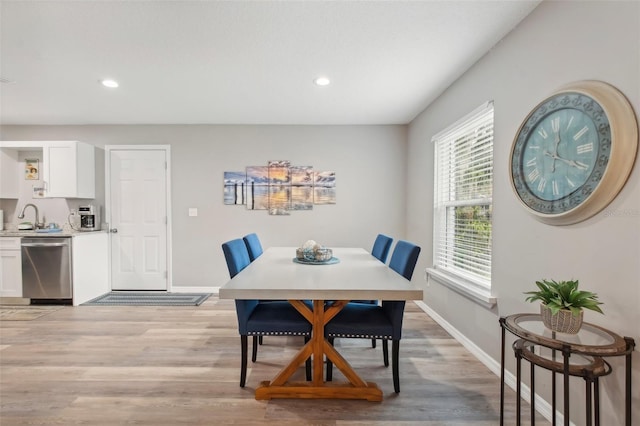 dining space featuring light wood finished floors, baseboards, and recessed lighting
