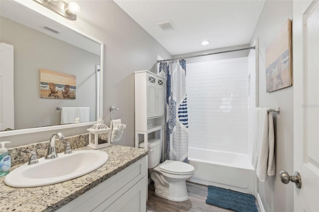 bathroom with visible vents, toilet, vanity, and shower / bath combo