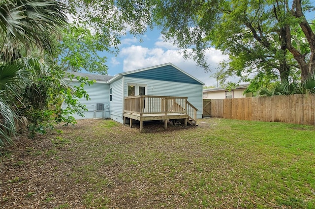 back of property featuring cooling unit, a wooden deck, a fenced backyard, crawl space, and a lawn